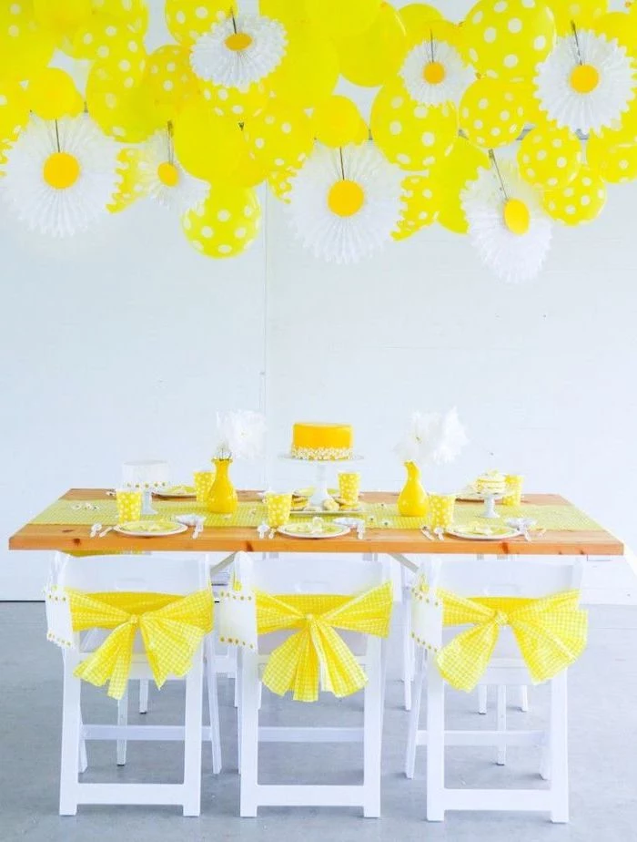 diy baby shower decorations, yellow decor, wooden table, white chairs, hanging yellow balloons, table setting