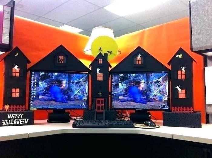 halloween decor, office cubicle accessories, two desktops, white desk, orange wallpaper, desk lamp