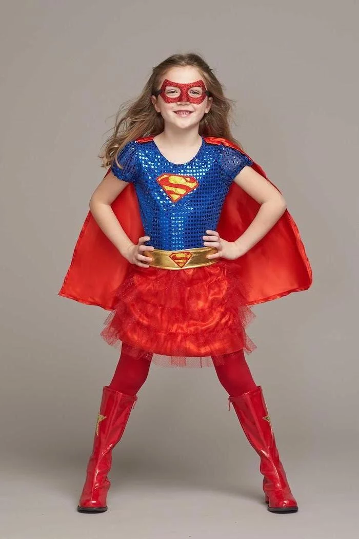halloween costumes for girls, girl dressed as supergirl, blue sequinned top, red tulle skirt, red cape