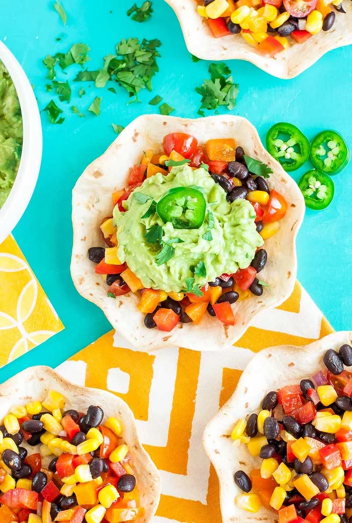 tortilla bowls, filled with corn, chopped vegetables, black beans, best taco seasoning, turquoise table