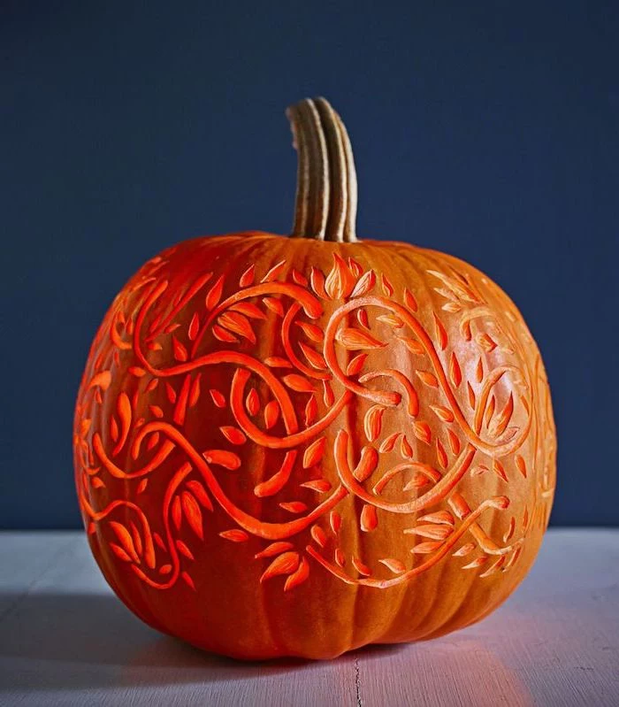 blue wall, funny pumpkin carving, floral motifs, carved into a pumpkin, lit by a candle