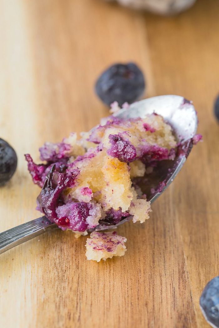 keto diet recipes, blueberry muffin, on a spoon, blueberries scattered around, on wooden table