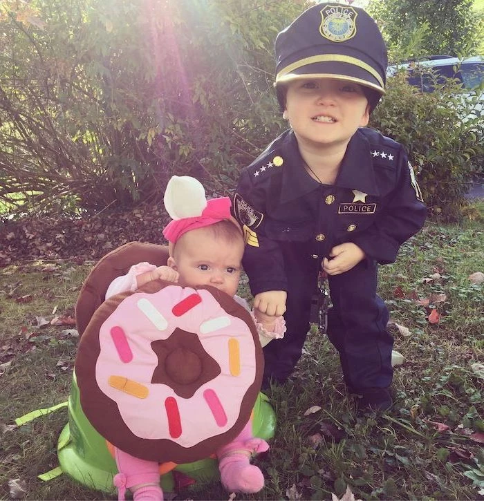 baby dressed as a donut, boy dressed as apolice officer, holding hands, halloween costumes for kids girl