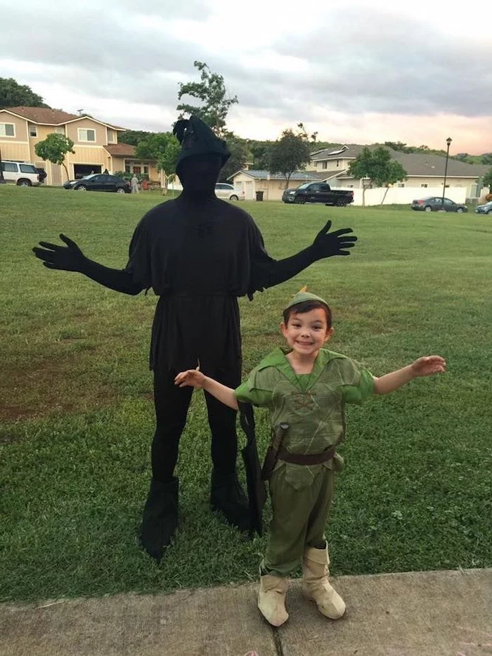 boy dressed as peter pan, man dressed as his shadow, toddler boy costume, standing on a grass field