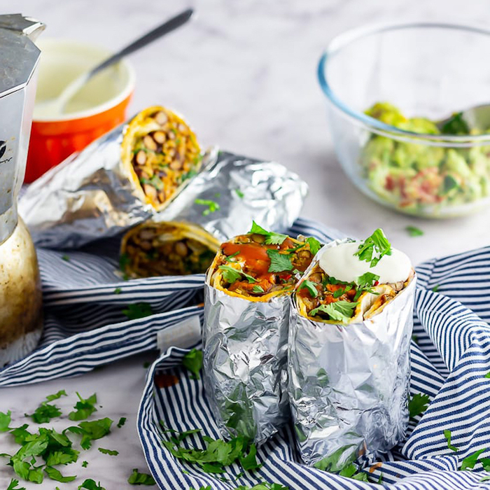 breakfast burritos, easy meal prep ideas, wrapped in foil, covered in parsley, black and white, striped cloth