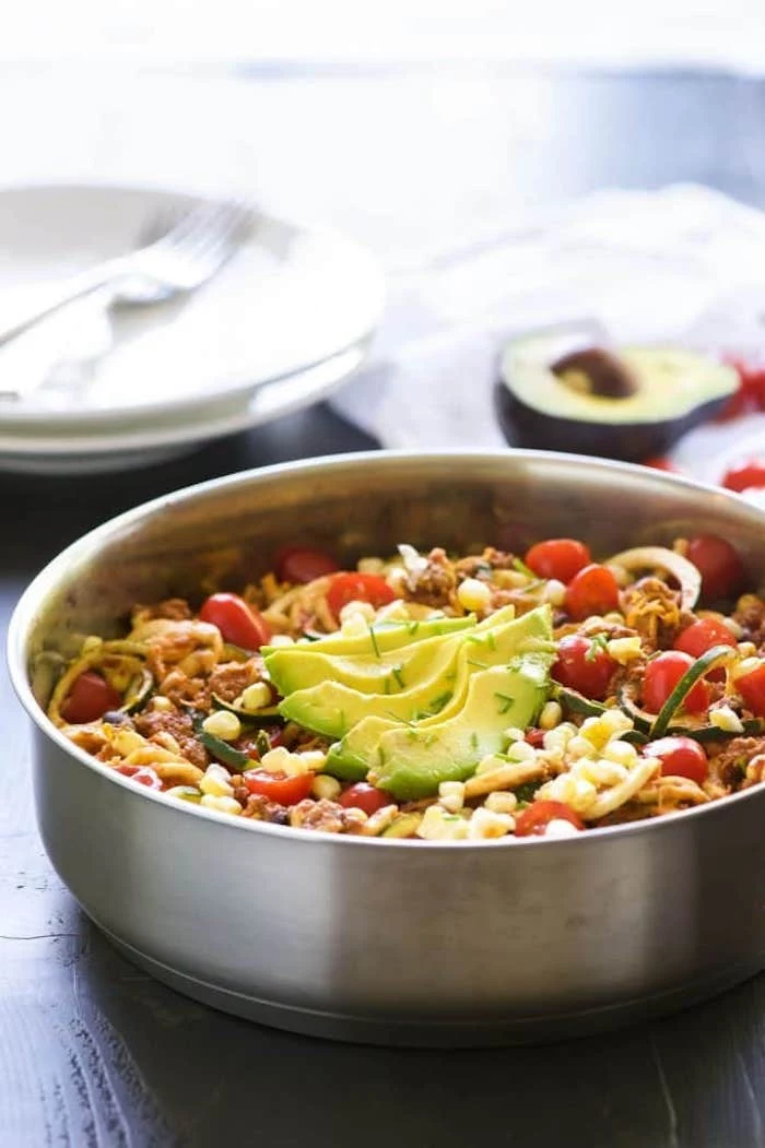 taco zoodles, how to make zucchini noodles, cherry tomatoes, avocado slices, corn and turkey, in a skillet