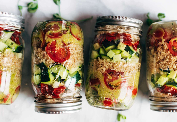 healthy meal prep recipes, four mason jars, filled with salads, quinoa and cucumbers, cherry tomatoes