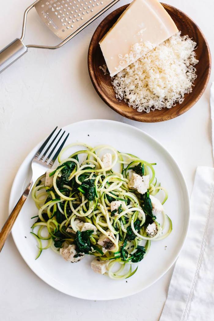 grated parmesan, zucchini noodles recipe, with chicken fillet, spinach and parmesan, white plate, wooden bowl
