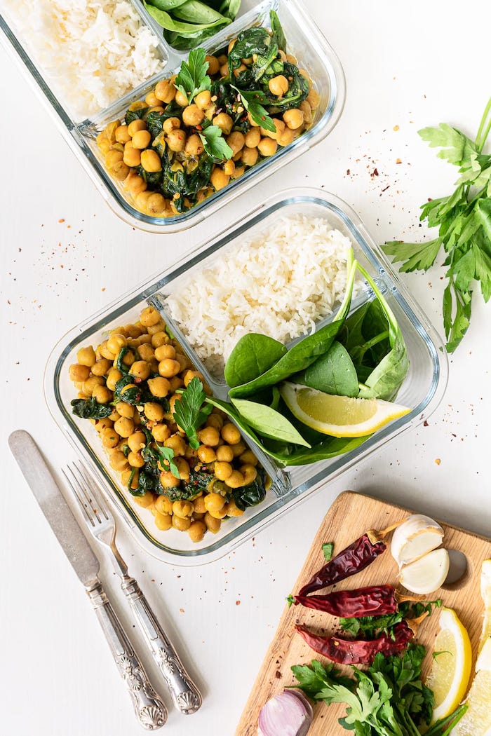 chickpeas and parsley, rice and spinach, inside a glass container, healthy meal prep, silver fork and knife