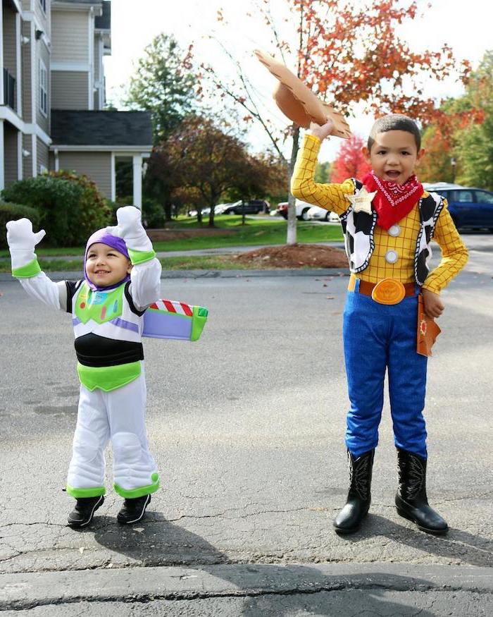 two boys, one dressed as woody, one dressed as buzz lightyear, toddler halloween costumes, toy story inspired