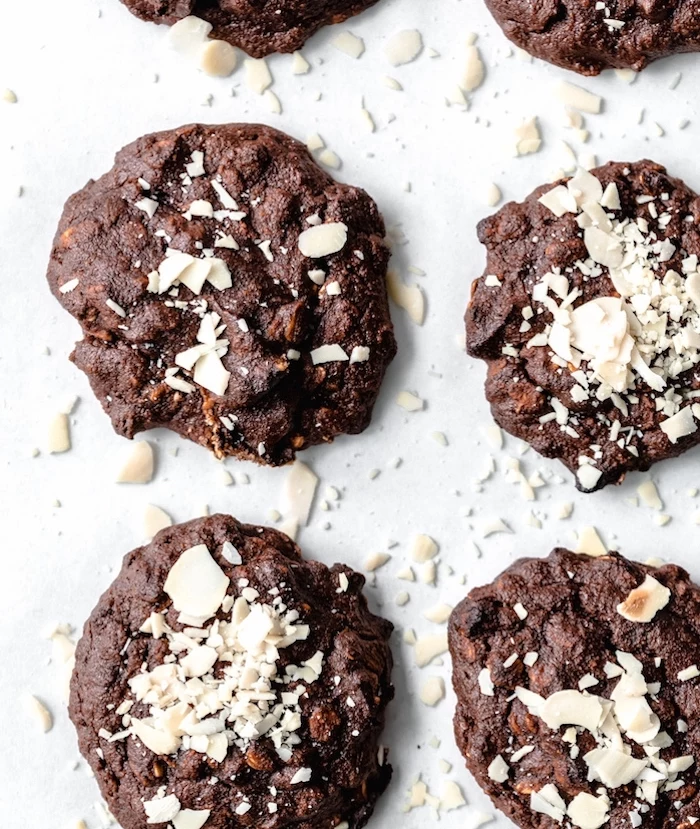 cocoa cookies, shaved almonds on top, easy chocolate chip cookies, arranged on white table