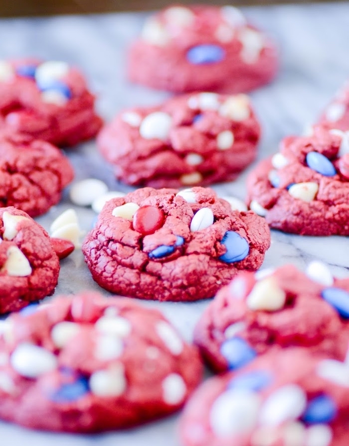 cookies colored in red, soft chocolate chip cookies, blue red and white candy, blurred background