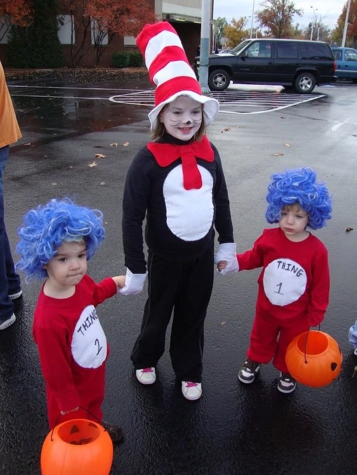 girl dressed as dr seuss, toddlers dressed as thing 1 and thing 2, toddler boy costume, standing on a parking lot