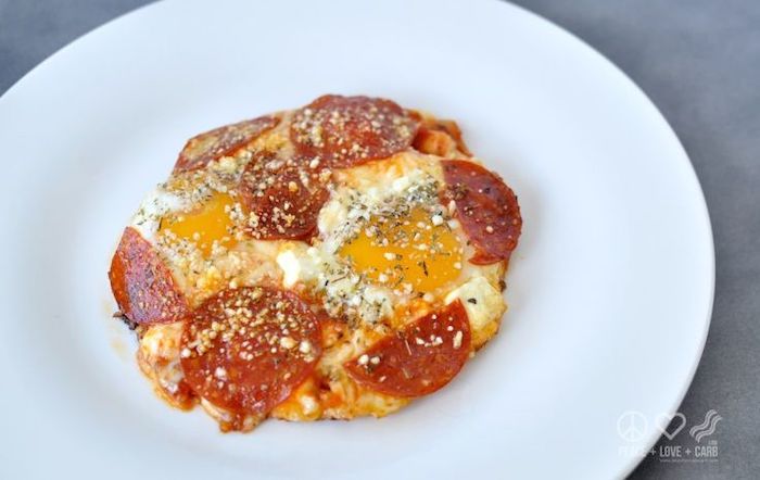 egg pizza, with pepperoni slices, keto diet breakfast, white plate, granite countertop