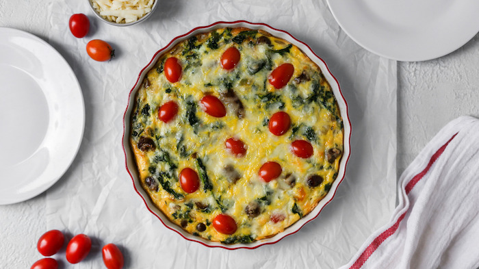egg and spinach casserole, with cherry tomatoes, low carb breakfast recipes, white baking paper, white plates