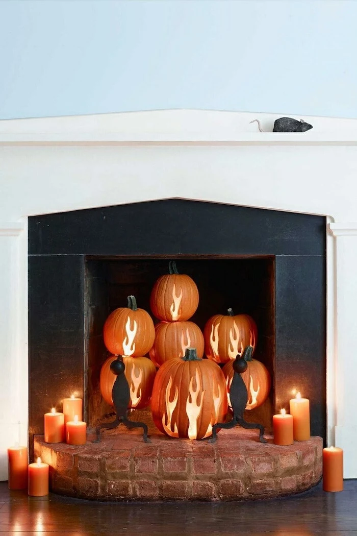 orange pumpkins, flames carved into them, pumpkin carving, arranged in a fireplace, lit by candles, halloween pumpkin faces to carve
