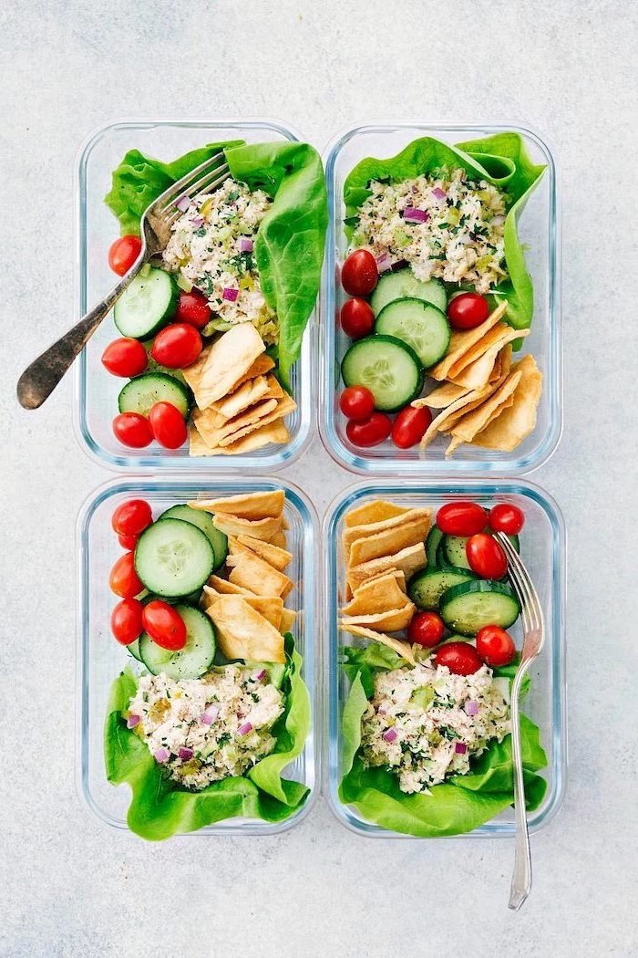 four glass containers, healthy lunches for work, tortillas and cucumbers, cherry tomatoes, green salad inside