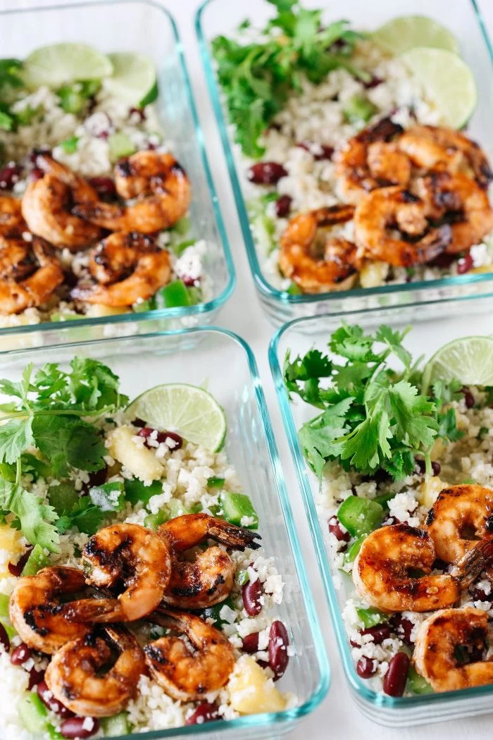 shrimp with rice, black beans, in a glass container, healthy lunch recipes, lime slices, parsley on the side