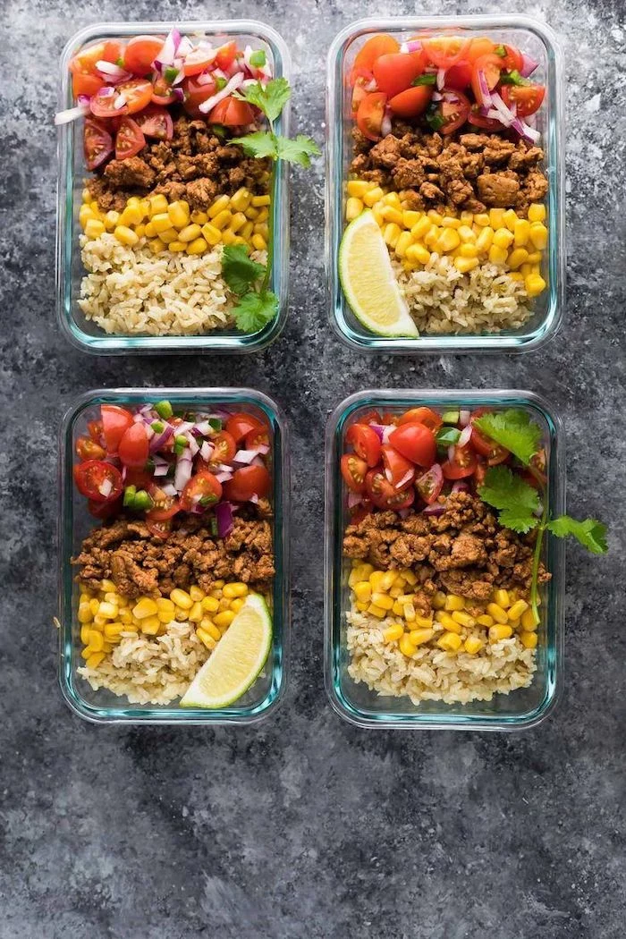 four glass containers, ground turkey, salsa and corn inside, lemon slice on the side, chicken meal prep