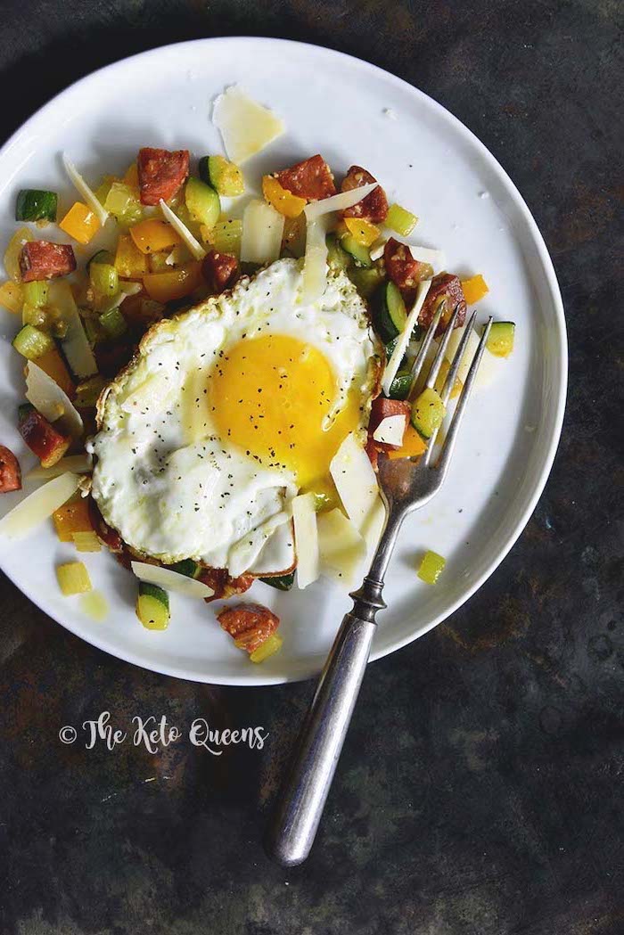 quick keto breakfast, fried egg, cooked vegetables, on white plate, silver fork