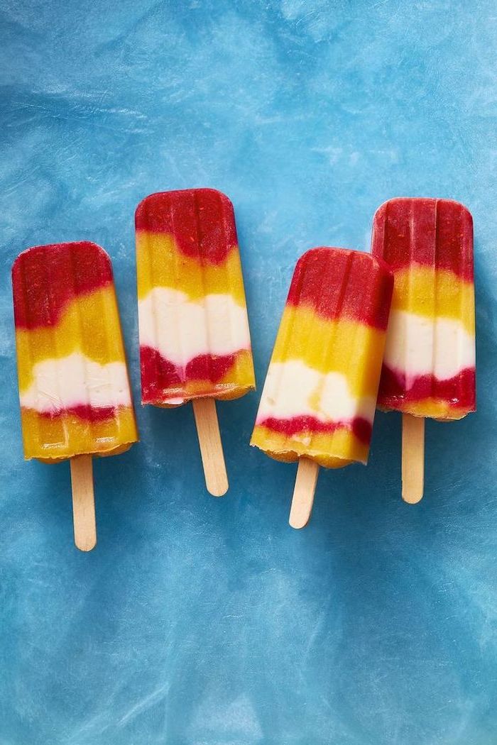 ice lollipops, red and yellow fruits, on wooden popsicle sticks, on a blue background, no bake desserts
