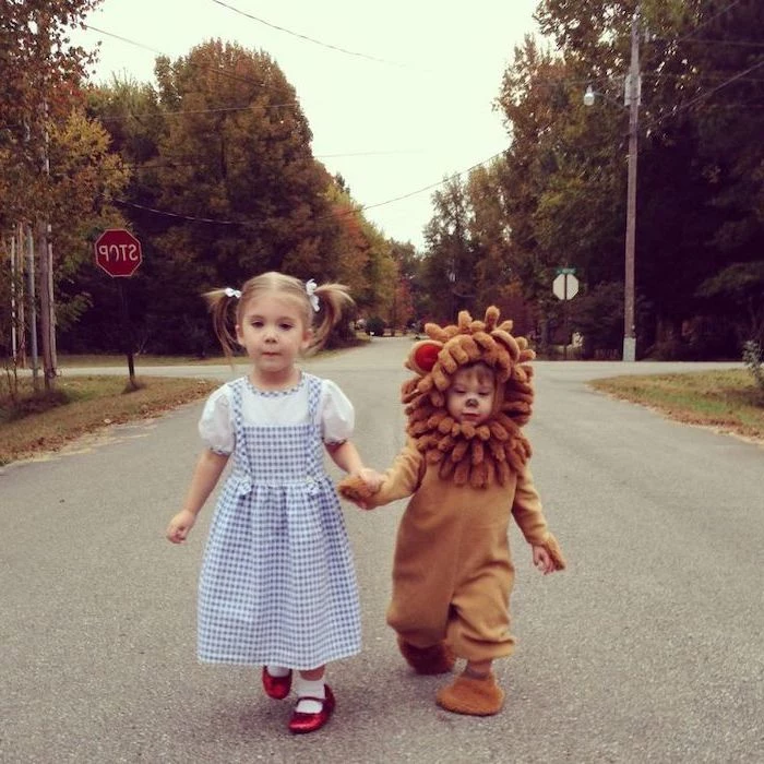 girl dressed as dorothy, boy dressed as cowardly lion, holding hands, cute halloween costumes for girls