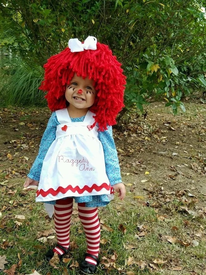 little girl, dressed as raggedy ann, wearing a red wig, face makeup, halloween costumes for kids
