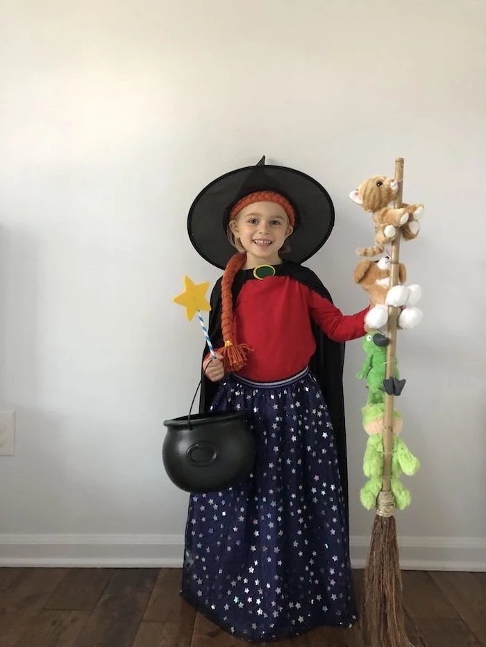cool halloween costumes, girl dressed as witch, room on the broom character, plush cat toys, white wall