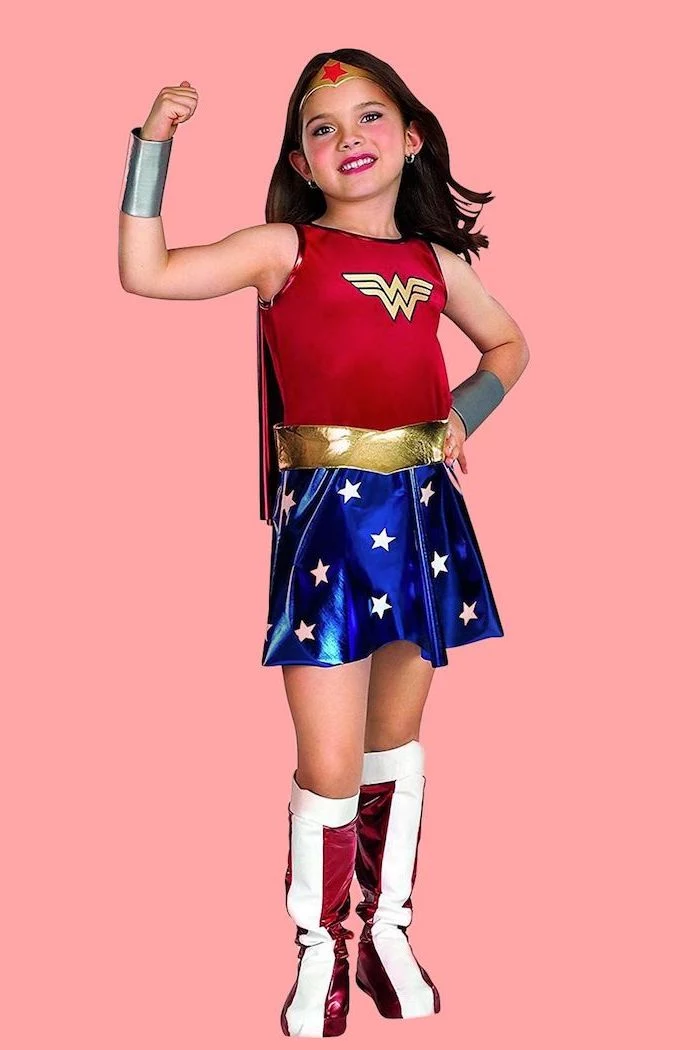 girl dressed as wonder woman, cool halloween costumes, red top, blue skirt, pink background