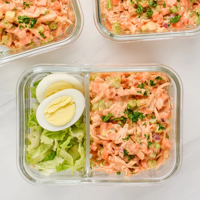 healthy meal prep ideas for weight loss, buffalo chicken salad, green salad, boiled egg, in a glass container