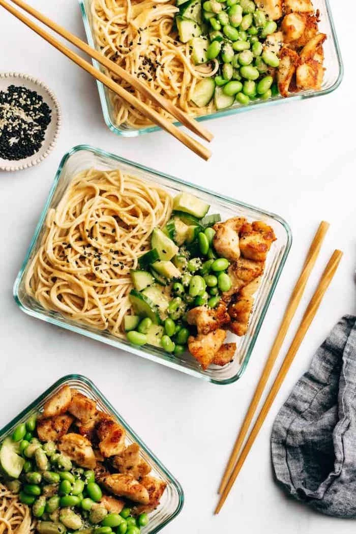 sesame noodles, healthy meal prep ideas, beans and cucumbers, chicken fillet, in glass containers