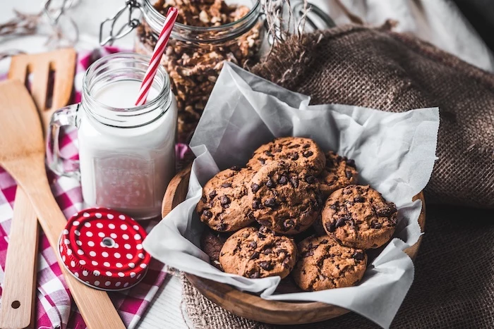 cocoa cookies, jar of milk, jar of nuts, chewy chocolate chip cookies recipes, in a wooden bowl, wooden spatulas