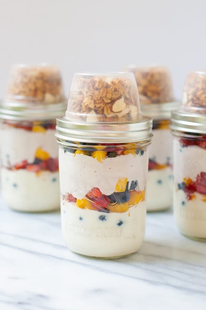 granola and yoghurt, healthy meal prep ideas for weight loss, berries and mango, inside a mason jar