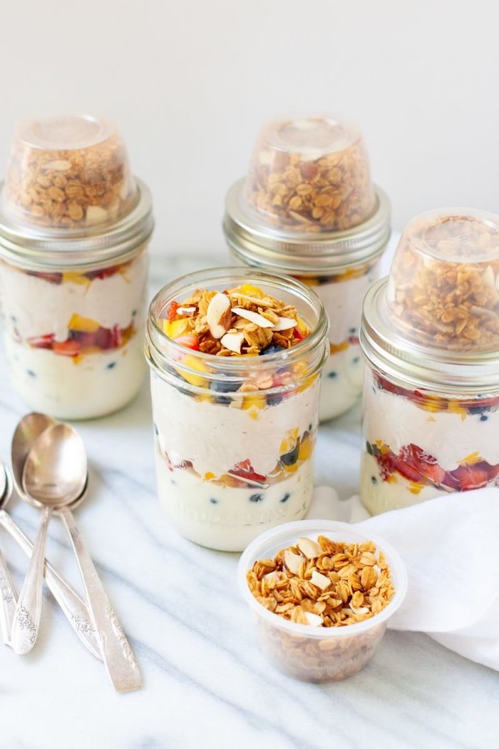 granola and yoghurt, mango and berries, inside mason jars, meal prep for the week, silver spoons