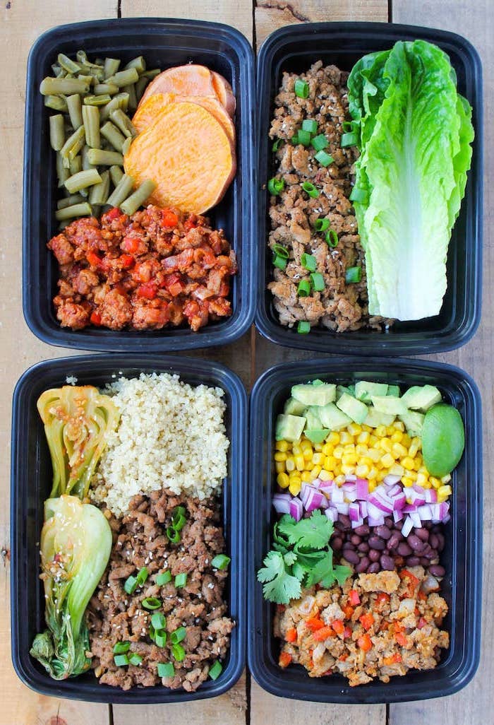 four plastic containers, with different meals inside, meal prep for the week, ground turkey, green salad