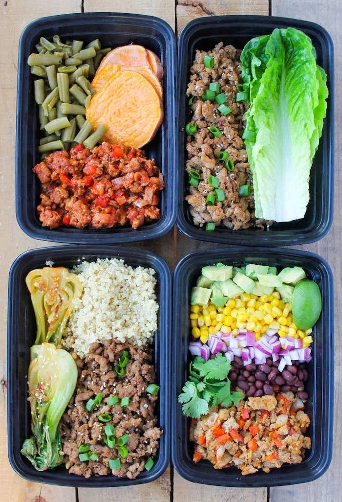 four plastic containers, with different meals inside, meal prep for the week, ground turkey, green salad