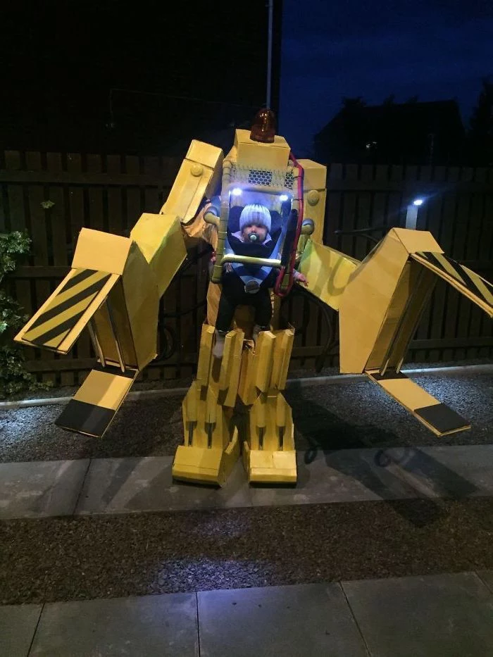 baby dressed as a robot, made of carton boxes, halloween costume ideas for girls, lights inside