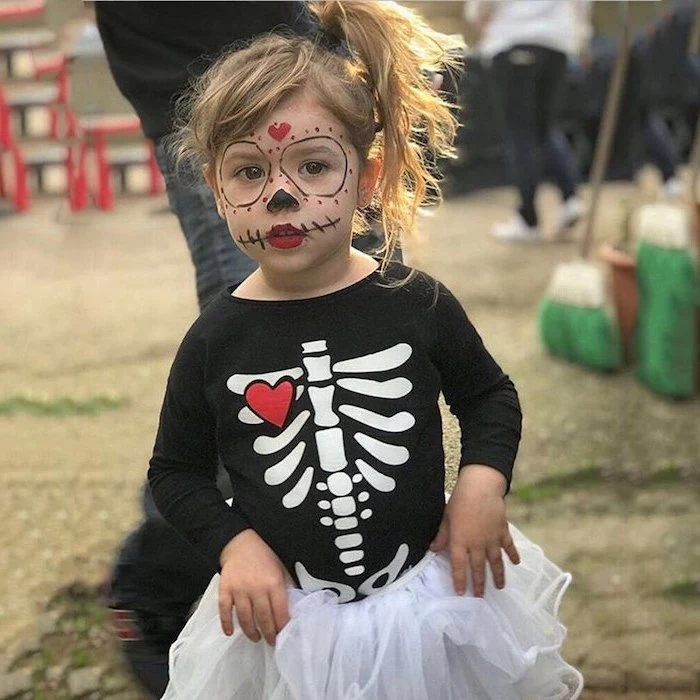 little girl, with blonde hair, dressed as skeleton, toddler boy halloween costumes, black shirt, calavera makeup
