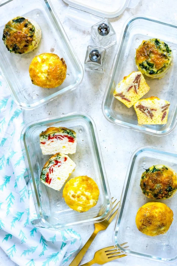 four glass containers, egg bites inside, meal prep, salt and pepper, brass forks