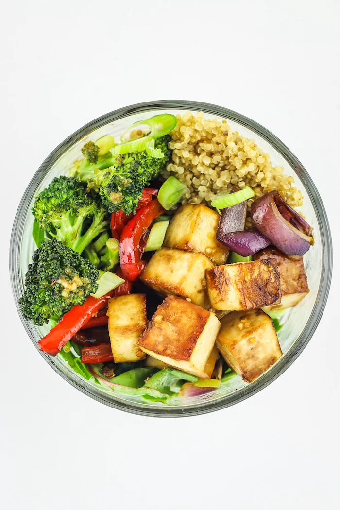 glass bowl, filled with quinoa, healthy lunch ideas for work, broccoli and peppers, tofu salad