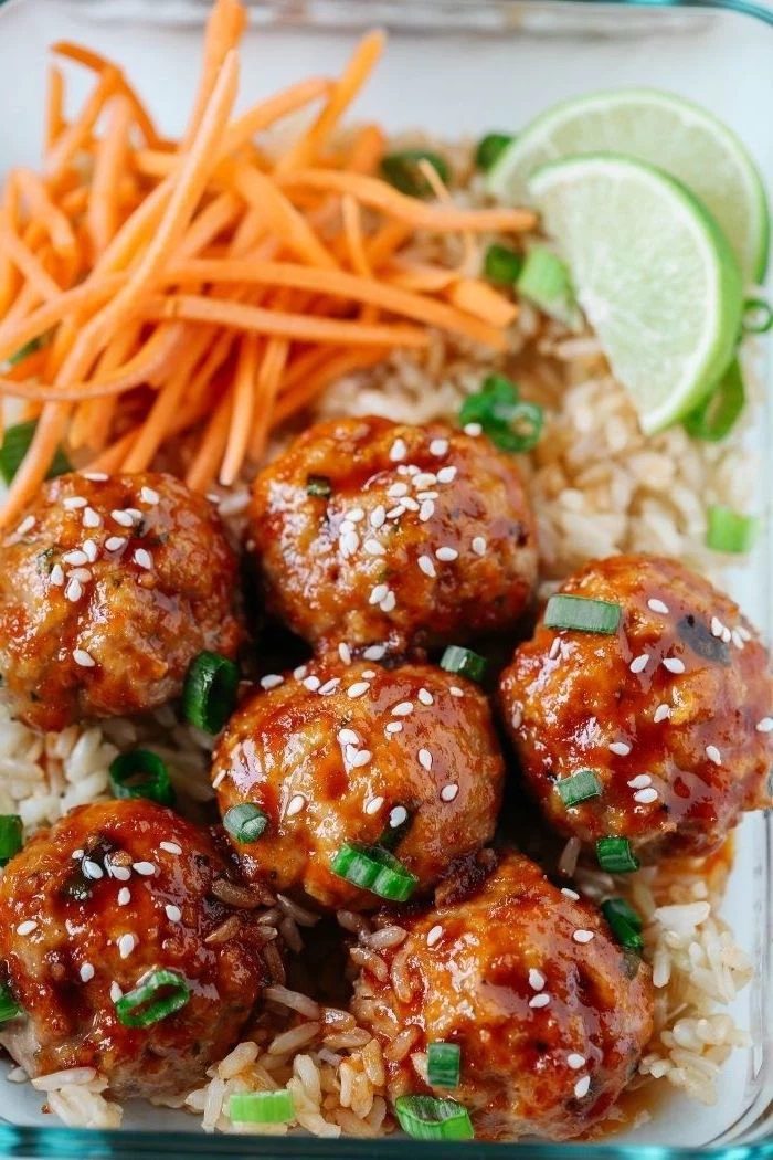 healthy lunch recipes, honey sriracha meatballs, rice and carrots, lime slices, in a glass container