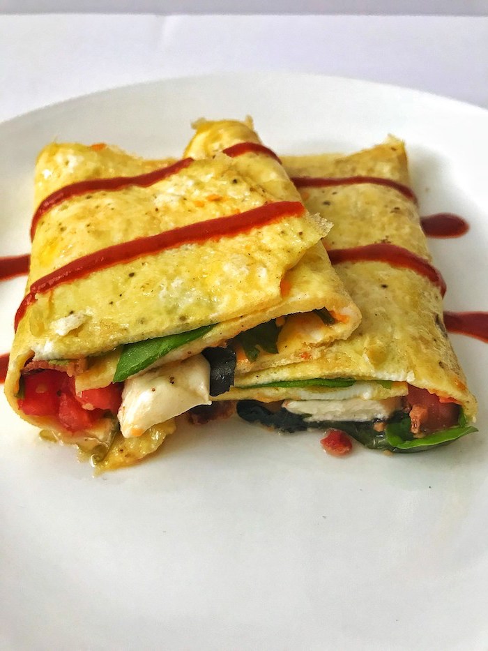 wrapped burritos, vegetables inside, quick keto breakfast, tomato sauce, drizzled on top, white plate