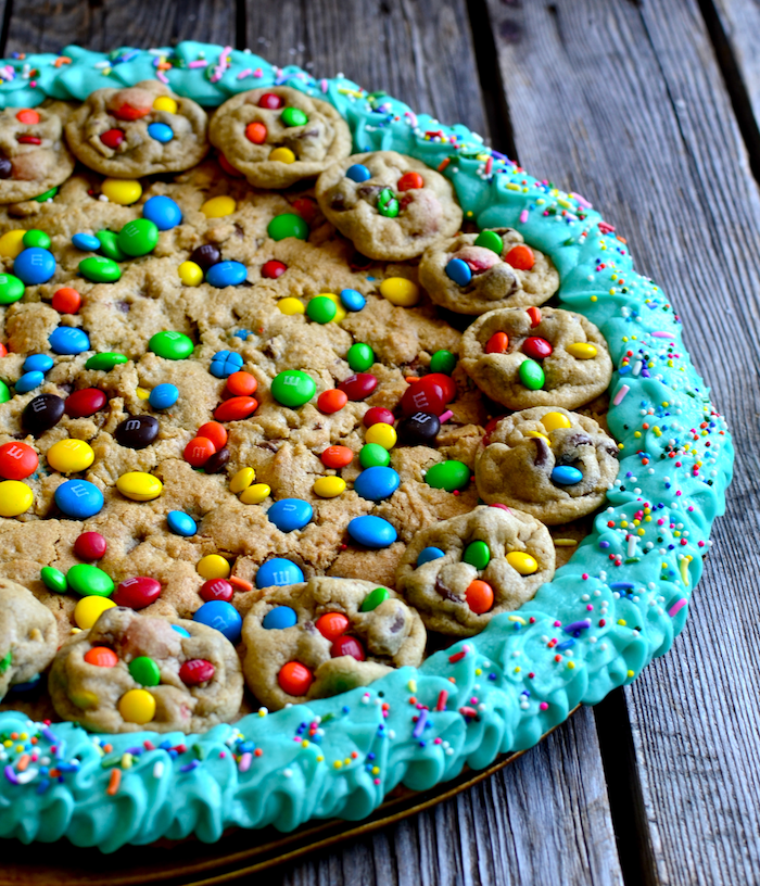 cookie dough cake, with smaller cookies, with m and ms, blue frosting around, how to make homemade cookies, wooden table