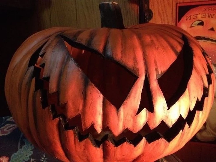 scary face, carved into a pumpkin, cute pumpkin carvings, wooden wall