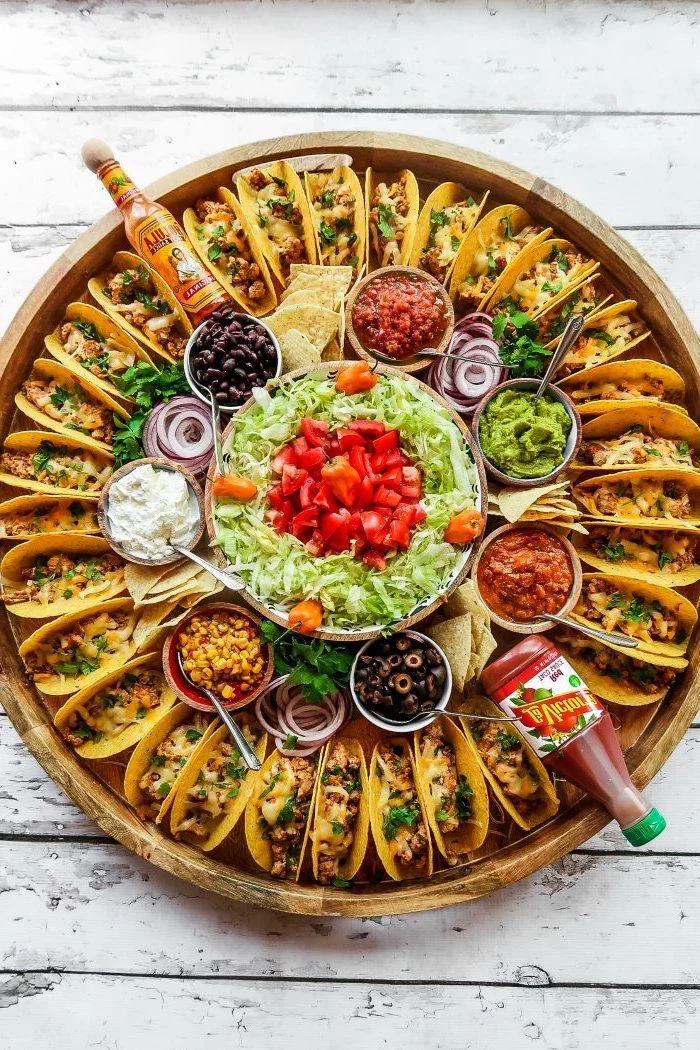 mini tacos, arranged on a large, wooden tray, glass bowls, filled with different ingredients, ground beef taco recipe