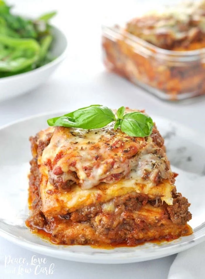 italian lasagna, with minced meat, cheese and tomato sauce, healthy lunch ideas for work, basil leaf on top