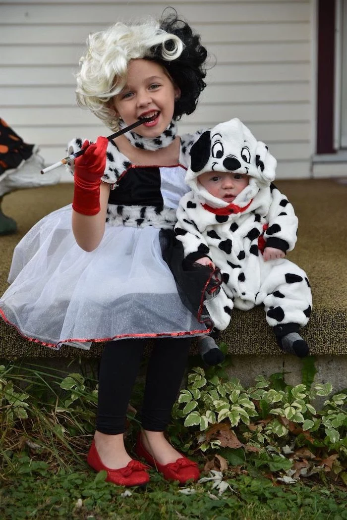 toddler girl halloween costume, girl dressed as cruella de vil, baby dressed as a dalmatian, sitting on a step
