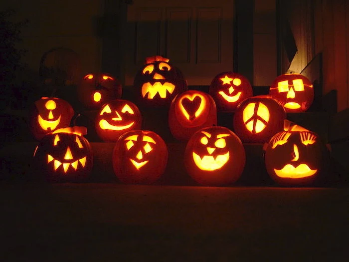 lot os pumpkins, lit by candles, arranged on a staircase, pumpkin carving faces