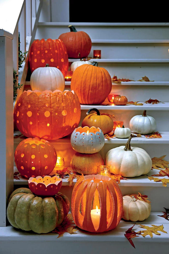 lots of pumpkins, lit by candles, arranged on white, wooden staircase, easy pumpkin carving
