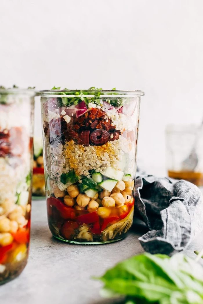 greek quinoa salad, inside a mason jar, meal prep for weight loss, with chickpeas and cucumbers, black beans